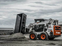Thumbnail for  The image shows a Bobcat skid steer loader with a bucket attached to the front. The loader is parked on a dirt surface, and there is a pile of dirt in front of the bucket.