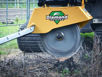 Thumbnail for A red Diamond Mowers stump grinder attachment mounted on a tractor is grinding a large tree stump into chips.