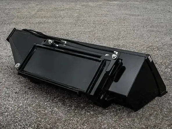 A black rectangular box sitting on top of a gravel road. 