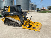 Thumbnail for A John Deere skid steer loader with a land leveler attachment parked on a dirt road.