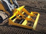 The land leveler is parked on a dirt lot.