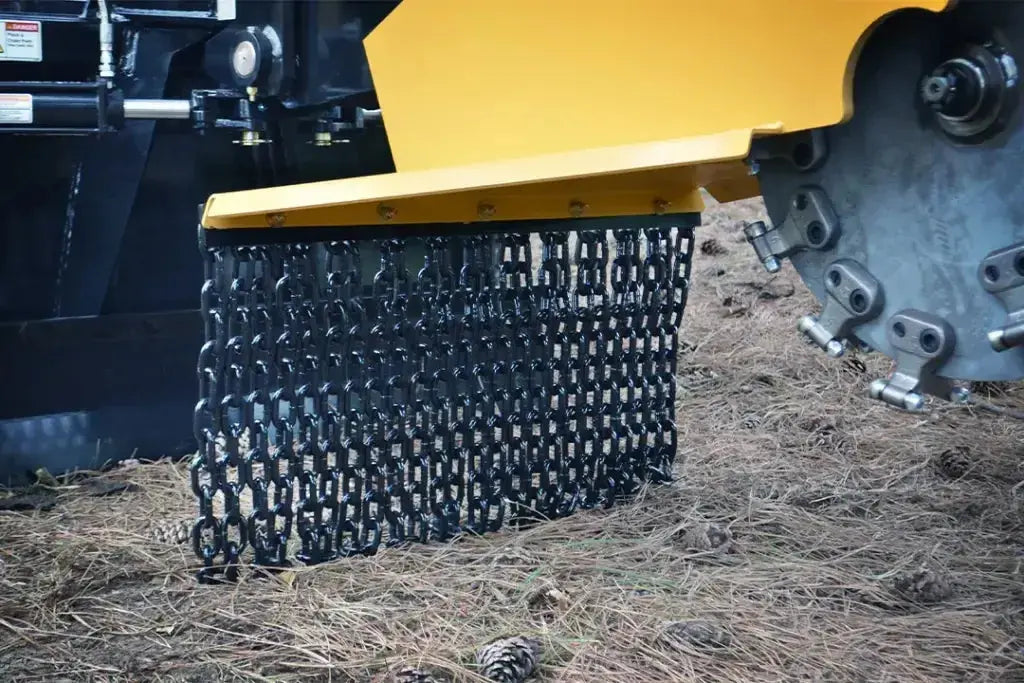 A close-up photo of a heavy-duty chain attached to a tractor, its links gleaming with a metallic sheen. The chain rests on top of a pile of freshly cut hay, its texture contrasting with the smooth metal.