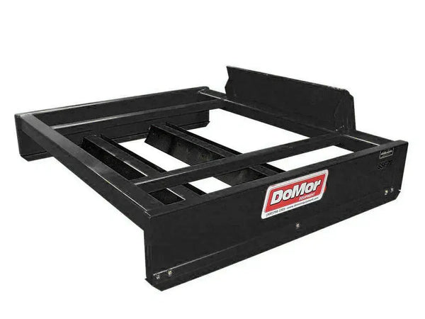 A close-up photo of a yellow DoMor SSF-72 hydraulic box grader attachment, designed for skid steers. The attachment sits on a white background. The photo focuses on the attachment's black and yellow branding, as well as its open-box design. Text on the side of the attachment reads "DoMor" and "SSF-72".