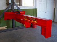 Thumbnail for A red hydraulic log splitter sitting in a room with a window and a door. The splitter has a vertical beam attached to a horizontal beam, with a wedge on the end of the vertical beam. There is a control panel on the side of the machine.