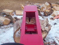 Thumbnail for A red TM Pro skid steer log splitter sitting on top of a pile of logs in the snow. 